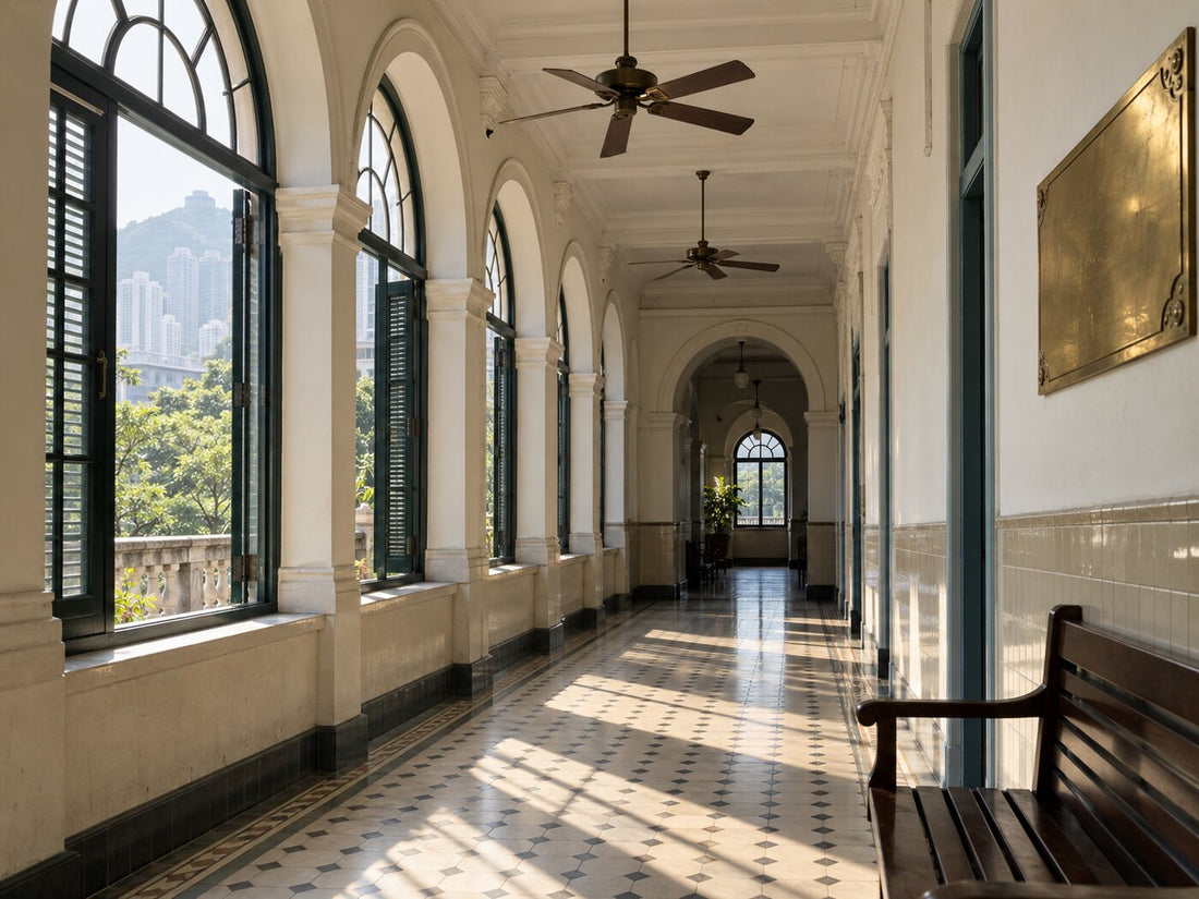 A colonial-era hospital corridor with arched windows, a tiled floor and a brass plaque