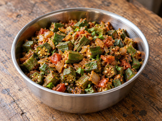 Semi-dry cooked okra chunks with softened chopped onion and tomato, light brown-red spice coating, no gravy, a little chopped coriander, generated illustration