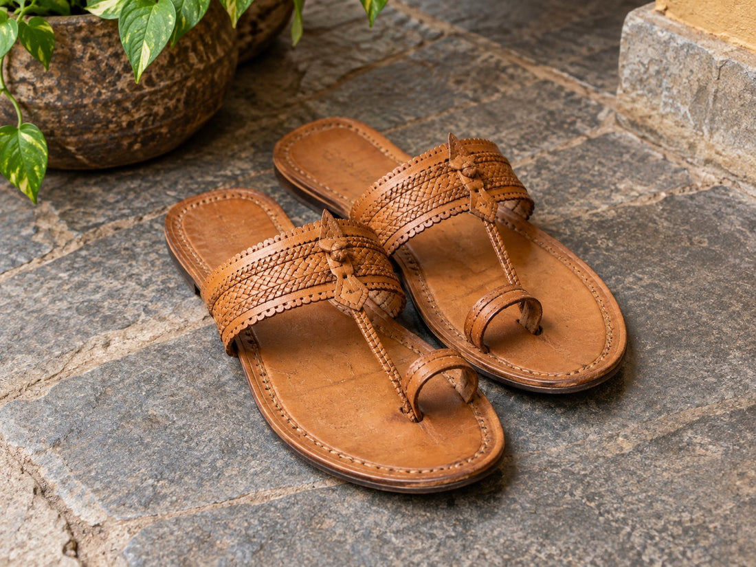 Illustrative Kolhapuri-style tan leather sandals with toe rings.