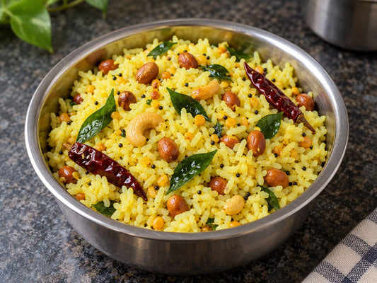 Illustrative yellow lemon rice with peanuts, cashews and curry leaves.